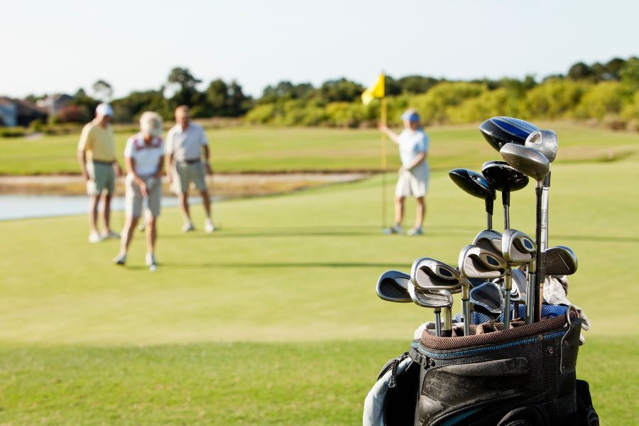 Golfers walking together on fairway during sunny round